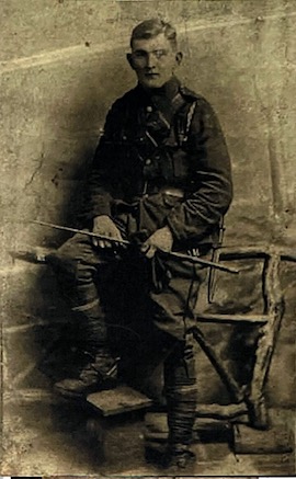 Black and white studio portrait of a young man in military uniform
